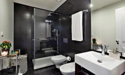 a bathroom with a sink and a toilet and a shower at Lisbon Five Stars Apartments Bica in Lisbon