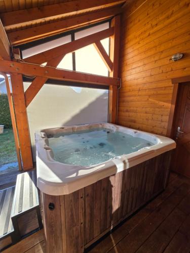 a jacuzzi tub in a wooden building at Le Chalet d'AxEllie Spa et Confort in Anould