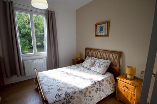 a bedroom with a bed and a window at Gîte Aux Tuileries in Noaillan
