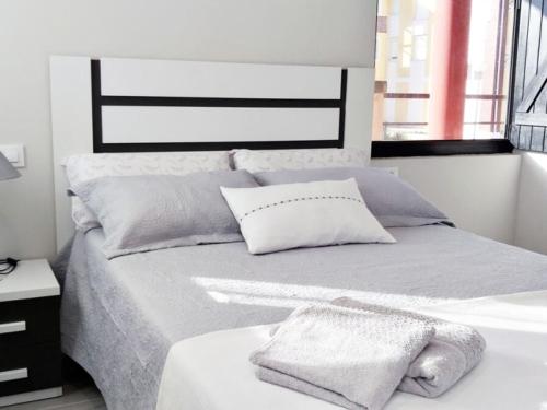 a white bedroom with a bed with a bath tub at Apartamentos los Acantilados Nº 1 Cobreces in Cóbreces