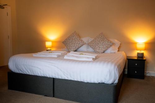 a bedroom with a bed with two lamps on it at The George Inn in Tideswell