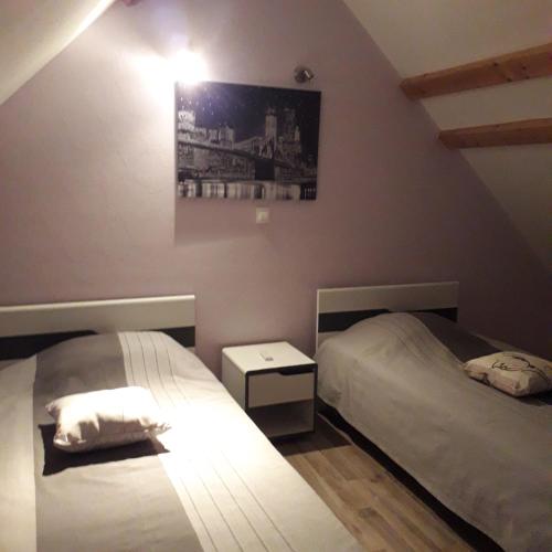 a bedroom with two beds and a picture on the wall at L etoile bleue in Fossé