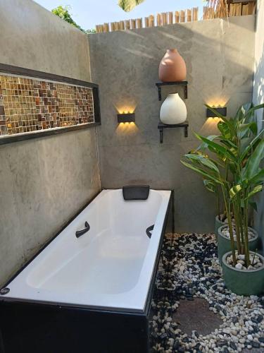 a bath tub in a room with a plant at Do Dee cafe in Bangkok