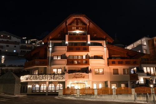 a building with a lit up facade at night at Hotel Garni Alpenhof in Ischgl