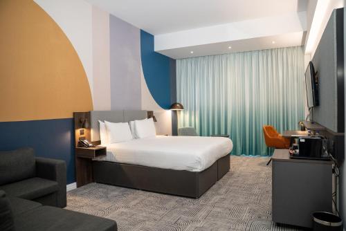 a hotel room with a bed and a tv at Holiday Inn London - Whitechapel by IHG in London