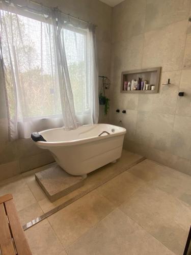 a white bath tub in a bathroom with a window at Casa Penedo Vista da Serra in Itatiaia