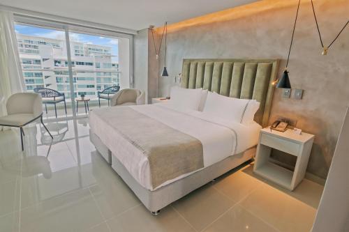 a bedroom with a large bed and a balcony at Sonesta Hotel Cartagena in Cartagena de Indias