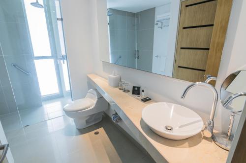 a bathroom with a sink and a toilet and a mirror at Sonesta Hotel Cartagena in Cartagena de Indias