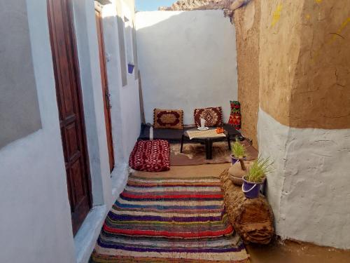 a room with chairs and a table and a rug at Bivouac beauté du désert in Mhamid