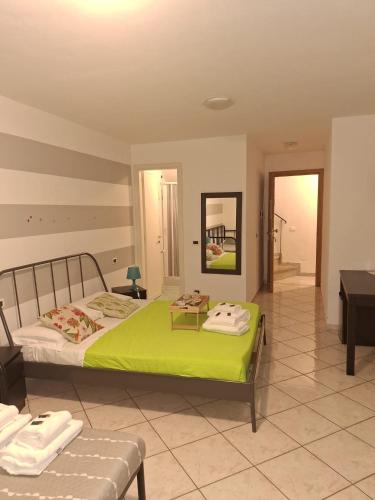 a bedroom with a bed with a green blanket at San Antonio 50 CA del MOETTO in Riomaggiore