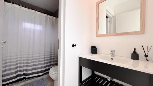 a bathroom with a sink and a mirror at Marea Baja - Casa con vista al mar para 6 PAX con parrilla en Cruz del Sur, Chapadmalal - Hola Sur in Chapadmalal