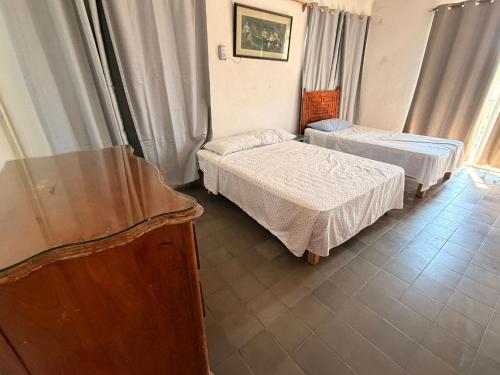 a hotel room with two beds and a television at Casa del trébol in Acapulco