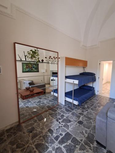 a room with a bedroom with a bunk bed and a mirror at Domus Solis Salento in Campi Salentina