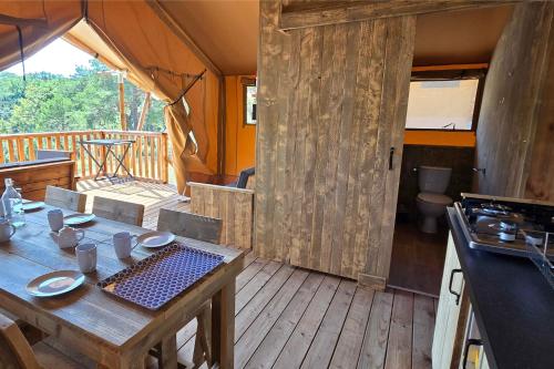 a kitchen with a wooden table in a room at Camping Saint-Laurent-du-Verdon in Saint-Laurent-du-Verdon