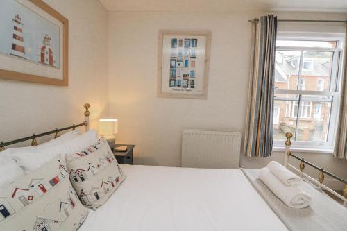 a bedroom with a white bed and a window at Shipwrights, 11 Coronation Road in Salcombe