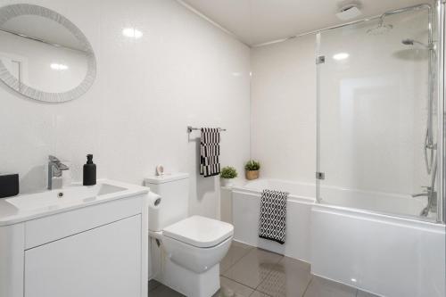 a white bathroom with a toilet and a tub and a sink at Creel Cottage, Peterhead in Peterhead