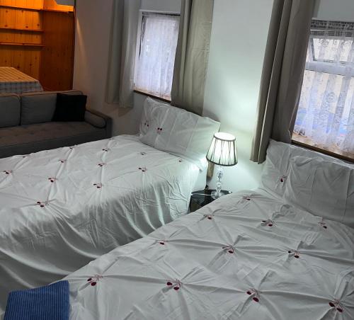 a bedroom with two beds with white sheets at Clayburn Spacious Twin Bed Large Room in Basildon