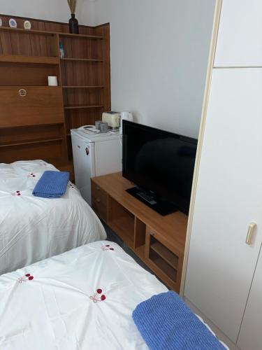a room with two beds and a flat screen tv at Clayburn Spacious Twin Bed Large Room in Basildon