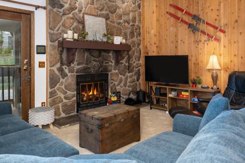 a living room with a stone fireplace and a tv at Silverado II Unit 334 in Winter Park