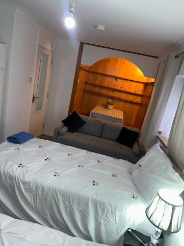a bedroom with a large bed and a couch at Clayburn Spacious Twin Bed Large Room in Basildon