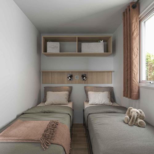 a room with three beds with a teddy bear sitting on them at Camping Loches in Loches