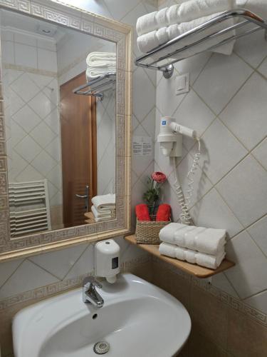 a bathroom with a sink and a mirror and towels at Cozy Nook Stays near Rogla & Terme Zreče in Zreče