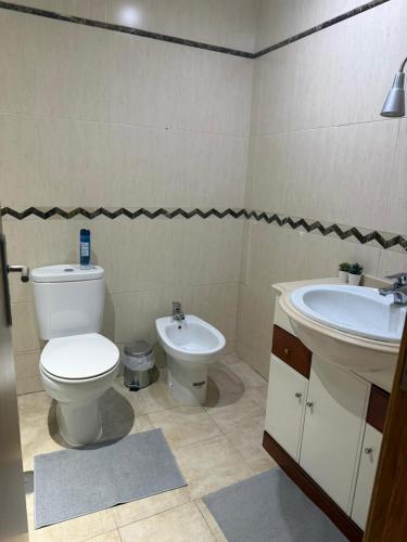 a bathroom with a toilet and a sink at Elegant Getaway - Spacious 3 Bedroom Apartment -Lisbon Baixa da Banheira in Lavradio
