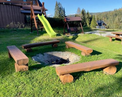 a park with wooden benches and a slide at Chata Ballek Oravice in Vitanová