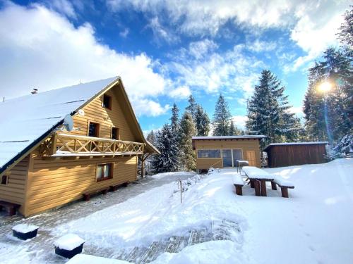 a log cabin in the snow with a picnic table at Chata Ballek Oravice in Vitanová