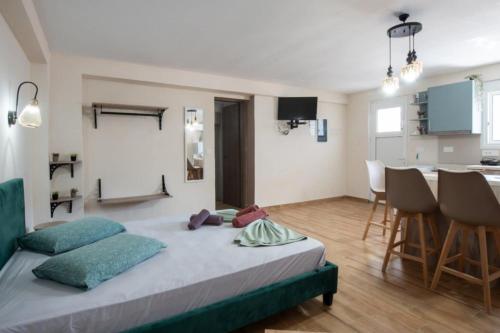 a bedroom with a large bed and a kitchen at Stergios Suite with Private Jacuzzi in Kolymbia