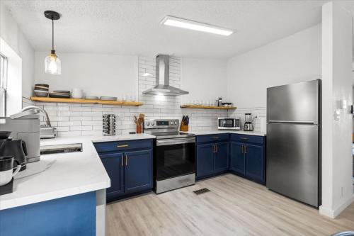 a kitchen with blue cabinets and a stainless steel refrigerator at Starlight Horizon in Canyon Lake