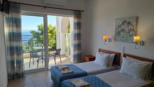 a hotel room with two beds and a balcony at Ninareti Studios in Agia Paraskevi