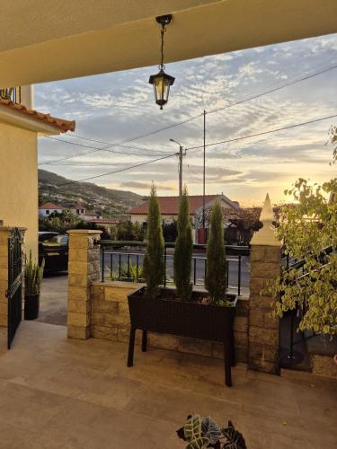 a patio with a bench and trees on a balcony at Hidden Corner by Sabugo House in Ponta do Sol