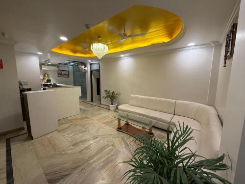 a living room with a couch and a yellow ceiling at Hotel Valentines in Prayagraj
