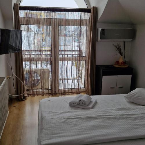 a bedroom with a bed and a large window at Hotel Casa Traiana in Alba Iulia