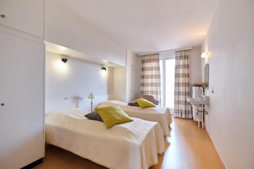 a hotel room with two beds and a sink at Lecomte - The Shoreline Collection 6 in Ostend