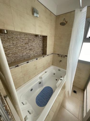 a large bathroom with a bath tub with a window at Jardines del Liceo in Comodoro Rivadavia