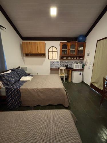 a living room with two beds and a kitchen at Recanto das Águas Claras in São José do Rio Prêto
