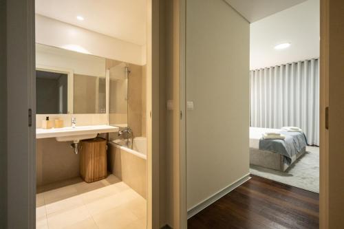 a bathroom with a sink and a bed at Funchal Next Corner Plaza in Funchal