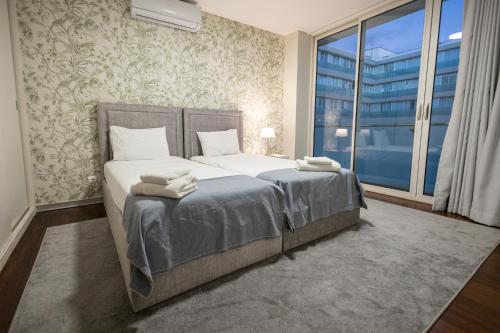 a bedroom with a bed and a large window at Funchal Next Corner Plaza in Funchal