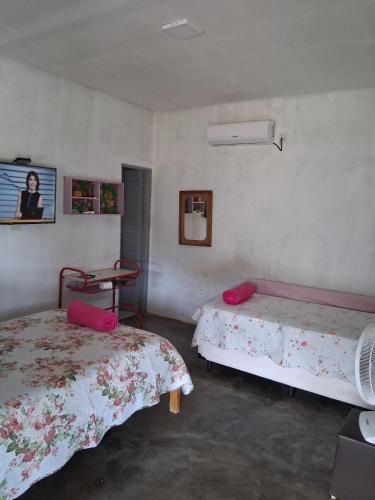 a room with two beds and a chair in it at CANTINHO DA ROSA ac - RIO PRIVATIVO in Manhã