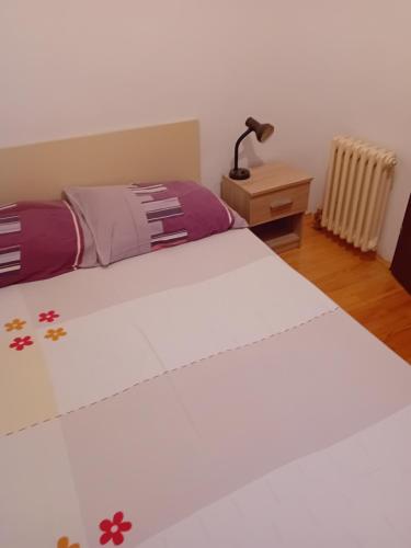 a bedroom with a bed and a lamp on a night stand at Tina in Jahorina