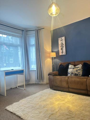 a living room with a couch and a window at Aldershot Spacious 3-Bedroom House with Fast Wi-Fi & Free Parking in Aldershot