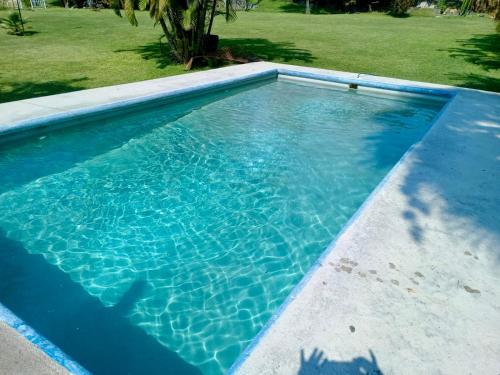 a swimming pool with blue water in a yard at Villas el Paraíso, El Rollo in Tlaquiltenango