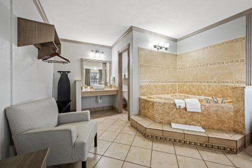 a bathroom with a tub and a chair in a room at Red Roof Inn College Station in College Station