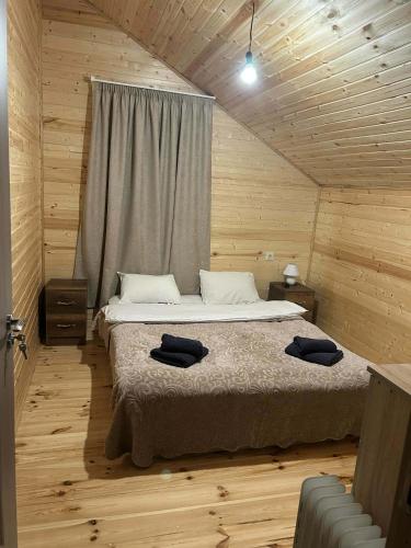 a bedroom with a bed in a wooden room at Cottage SUNNY in Itʼkhvisi