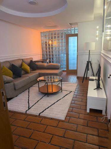 a living room with a couch and a table at Elegant Getaway - Spacious 3 Bedroom Apartment -Lisbon Baixa da Banheira in Lavradio