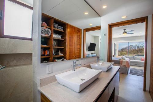 a bathroom with a sink and a living room at Alamar Vallarta in Cruz de Huanacaxtle