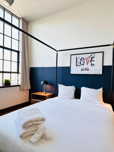a bedroom with a white bed with towels on it at Sosuite at Independence Lofts - Callowhill in Philadelphia