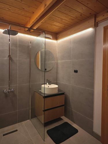 a bathroom with a sink and a shower at A Frames By Pensiunea Merișor in Răchiţele